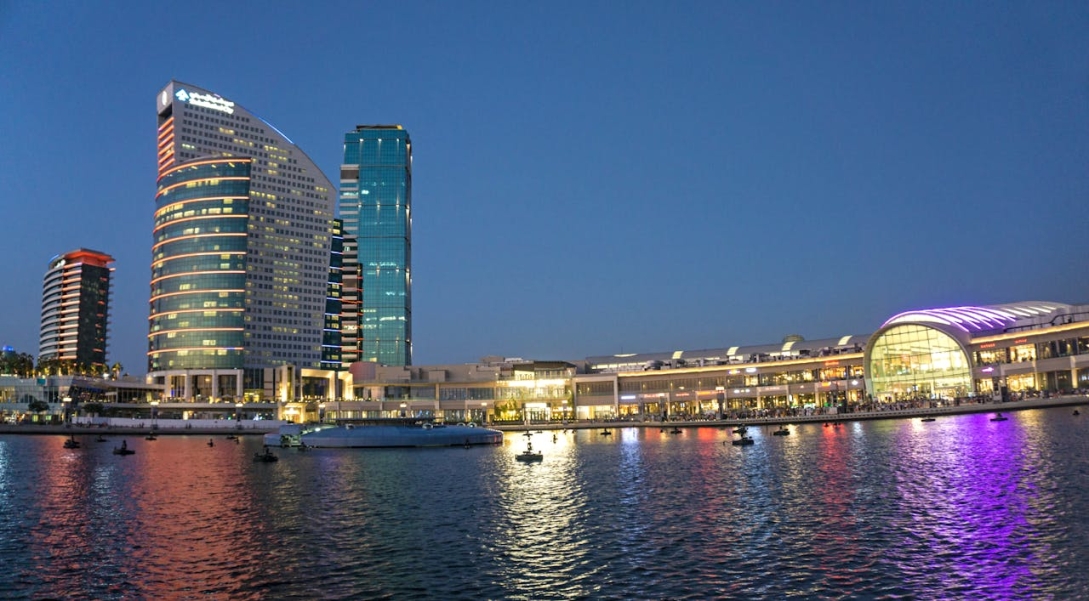 high rise building near water during night time in dubai